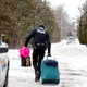 Police carries luggage of a woman and her family who told police they were from Sudan, in Hemmingford, Quebec, Canada, Feb. 12. (Reuters/Christinne Muschi)